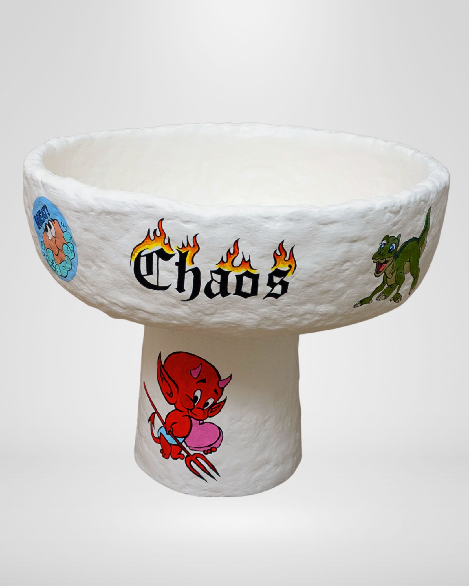 My Chaos, a hand-built paper pulp bowl with playful 90s childhood imagery on the exterior—Rocko’s Modern Life, Ducky, scratch-and-sniff stickers—and contrasting interior details including a pink flick knife, a yellow happy face lighter, a rolled stack of hundred-dollar bills, and a handwritten ‘PS I love you’ note, exploring nostalgia, desire, and hidden emotions in a tactile sculptural form.