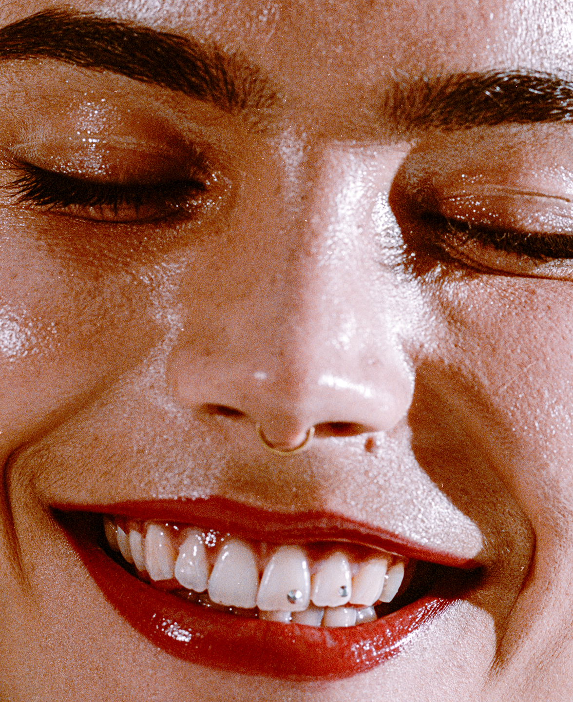close up portrait of a girl wearing red lipstick, smiling, with eyes closed